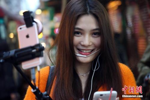 资料图:在旺角街头做直播的一位网红女孩。<a target= 点击进入下一页