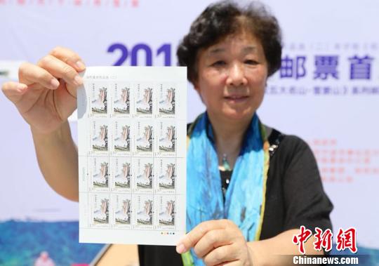 图为丰子恺外孙女杨朝婴展示《当代美术作品选(二)》丰子恺《仰之弥高》特种邮票 章勇涛 摄 图为丰子恺外孙女杨朝婴展示《当代美术作品选(二)》丰子恺《仰之弥高》特种邮票 章勇涛 摄